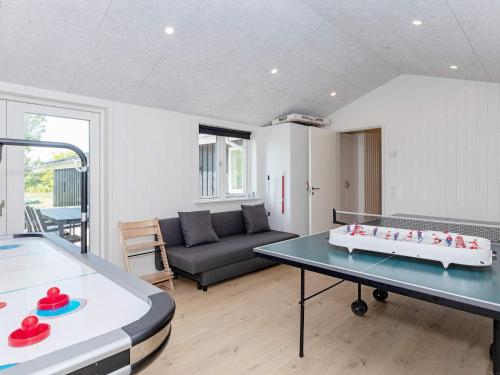 a living room with a ping pong table and a couch at Holiday home Bindslev XXIII in Bindslev