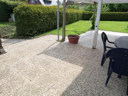 a patio with a table and chairs and an umbrella at Apartment Strandkorb by Interhome in Hooksiel