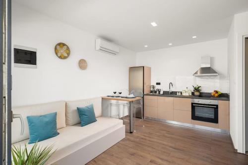 uma sala de estar com um sofá branco e uma cozinha em Nieva Apartment 1 em Matala