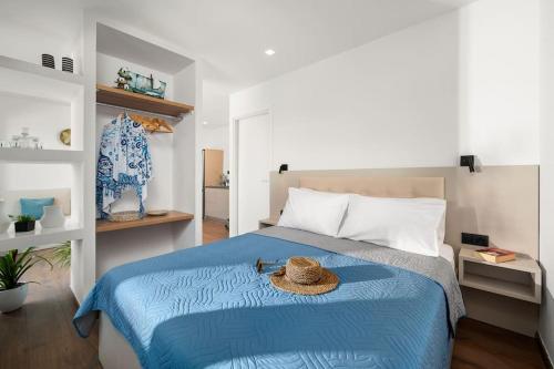 un dormitorio con una cama azul con sombrero en Nieva Apartment 1, en Matala