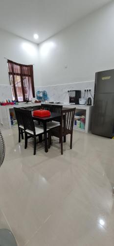 een eetkamer met een tafel en twee stoelen bij OLIA MEDINA KERTEH 4 BILIK HOMESTaY in Kampong Kemaman