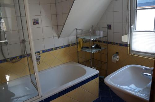 a bathroom with a tub and a sink at Gästehaus Sehl in Senheim