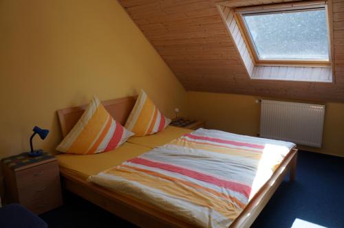 a small bedroom with a bed with a window at Gästehaus Sehl in Senheim