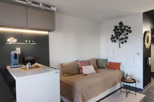 een kamer met een bed en een aanrecht in een kamer bij CADUCÉE Studio balcon ensoleillé parking nord Montpellier in Grabels