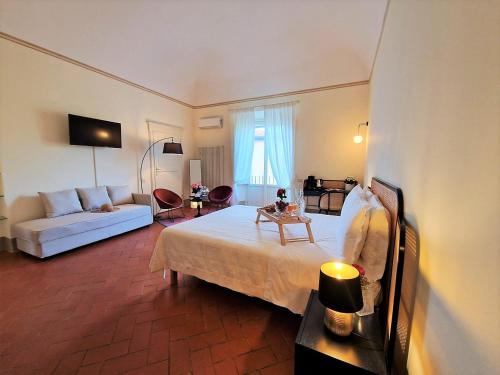 une chambre d'hôtel avec un lit et un canapé dans l'établissement Palazzo Rosselmini, à Pise