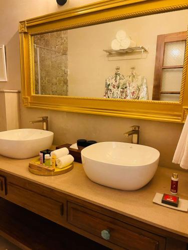 a bathroom with two sinks and a large mirror at The Postcard Saligao in Calangute