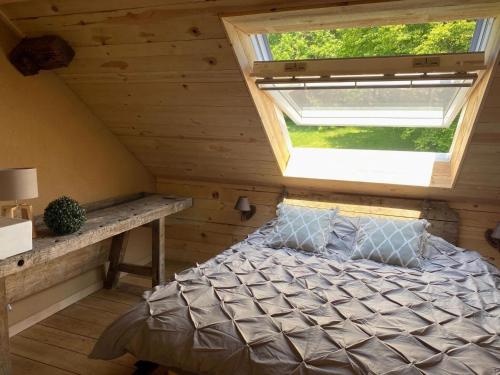 ein Schlafzimmer im Dachgeschoss mit einem Bett und einem Fenster in der Unterkunft Lush holiday home in Theux with heated indoor pool in Sprimont