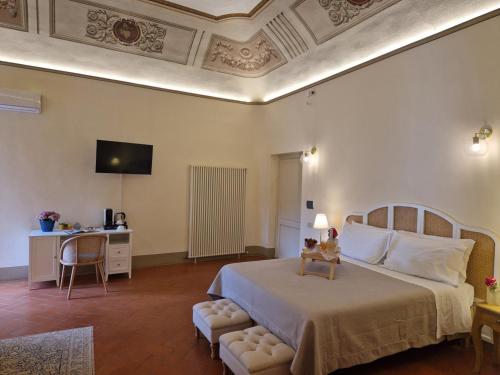 - une chambre avec un lit, un bureau et une télévision dans l'établissement Palazzo Rosselmini, à Pise