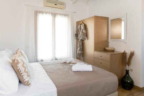 een slaapkamer met een bed met twee handdoeken erop bij Tethys 2 by Cretan Pnoe Adults Only in Chania