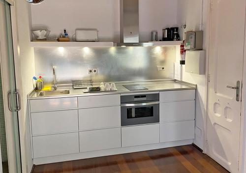 een keuken met een wastafel en een fornuis bij Barceloneta Suites Apartments Beach in Barcelona