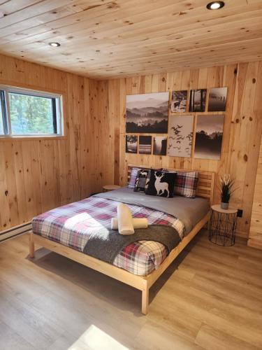 a bedroom with a bed in a wooden cabin at Spa calme au sommet in Saint Come