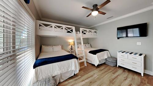 1 dormitorio con 2 camas y ventilador de techo en Sea La Vie Beach Cottage 3b2b - 2 Pools, en Gulf Shores