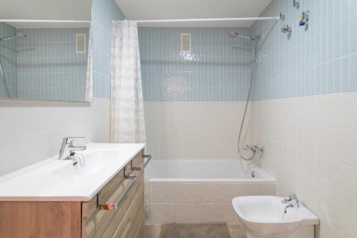 łazienka z umywalką, toaletą i wanną w obiekcie Duplex Sorolla w mieście La Venteta