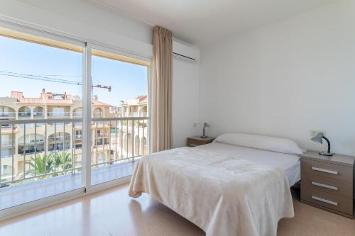 sypialnia z łóżkiem i dużym oknem w obiekcie Duplex Sorolla w mieście La Venteta