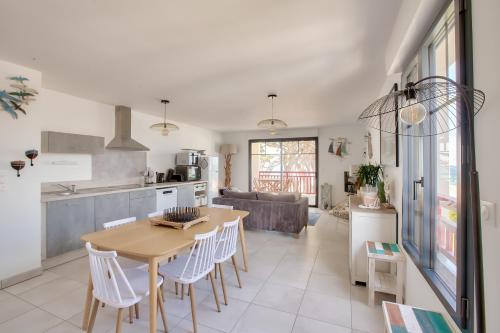 une cuisine et un salon avec une table et des chaises dans l'établissement Face à la mer, bel appartement pour 8, à Pléneuf-Val-André