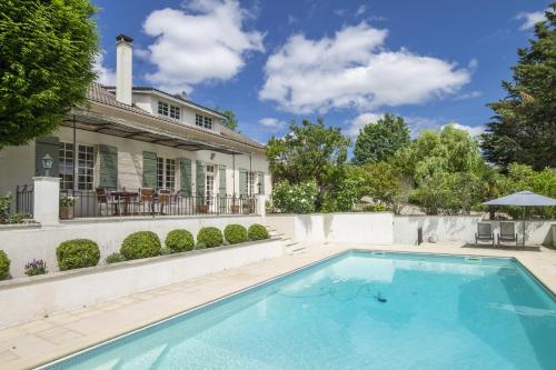 une piscine devant une maison dans l'établissement Boutouzet, à Villeneuve-sur-Lot