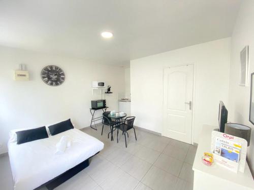 un salon blanc avec un canapé et une table dans l'établissement Le Vinci 2, à Calais