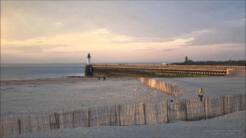 une personne se promenant sur la plage à côté d'une jetée dans l'établissement Le Vinci 2, à Calais