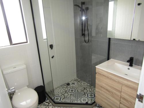 a bathroom with a shower and a toilet and a sink at L'il Southshore in Brentwood