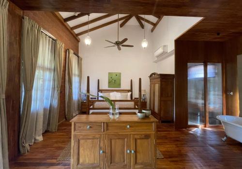 a living room with a ceiling fan and a tub at The Postcard Saligao in Calangute