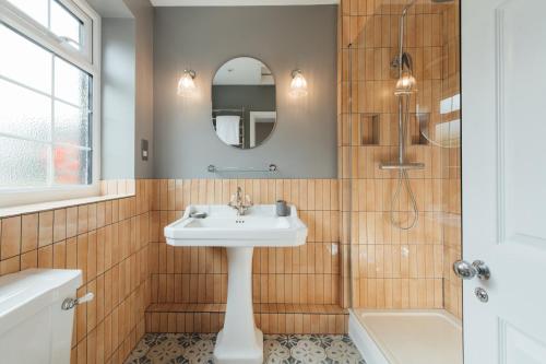 a bathroom with a sink and a mirror at The Farmhouse at Redcoats in Stevenage