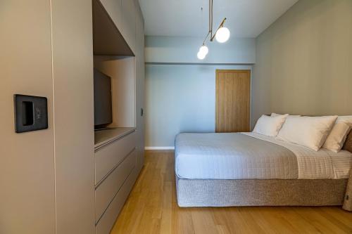 a bedroom with a bed and a flat screen tv at ICONIC SALONICA SUITE seafront in Thessaloniki