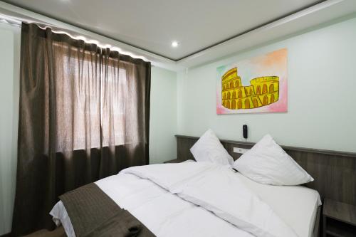 a bedroom with a white bed and a window at Bürgerhofhotel in Cologne