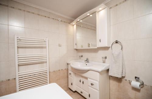 a white bathroom with a sink and a mirror at Serenitas, family house with great views in Sfakia