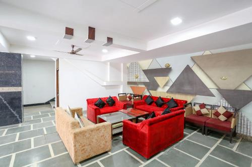 a living room with red chairs and a red couch at FabHotel Silver Crown in New Delhi