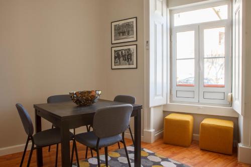 comedor con mesa, sillas y ventana en Alfama Graça district typical & bright , 3 bedroom apartment with AC 1st floor en Lisboa