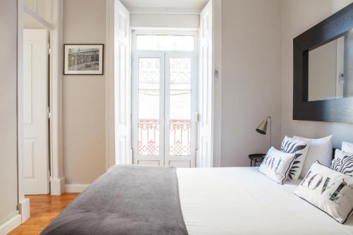 a bedroom with a large white bed with pillows at Alfama Graça district typical & bright , 3 bedroom apartment with AC 1st floor in Lisbon
