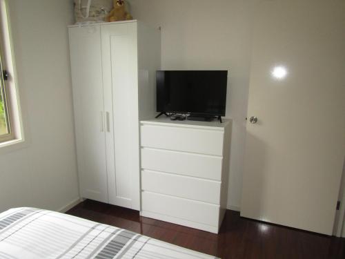 a bedroom with a television on a white cabinet at The Shack at Vincent in Port Vincent