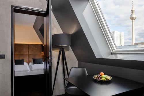 Zimmer mit einem Tisch, einem Fenster und einem Bett in der Unterkunft Hotel ZOE by AMANO in Berlin