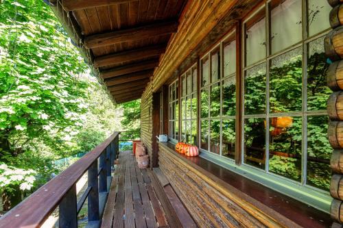 um alpendre de uma casa com janelas e árvores em Casa al Fiume by Quokka 360 - House by the River in the Verzasca Valley em Lavertezzo