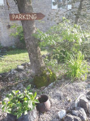 a sign that says parking next to a tree at La ferme de Roquedure in Montfaucon