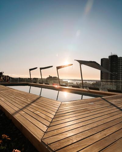 a wooden boardwalk with the sun in the background at Home Suite Hotels Station House in Cape Town