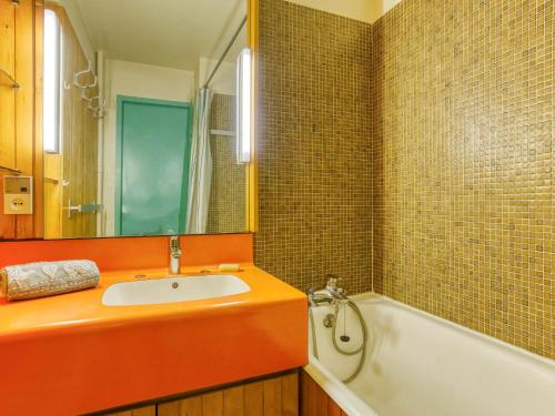 une salle de bain avec un lavabo, une baignoire et un miroir dans l'établissement Studio Chavière 116 by Interhome, aux Menuires