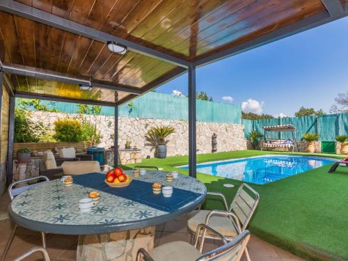 une terrasse avec une table, des chaises et une piscine dans l'établissement Holiday Home Aguilera by Interhome, à Maçanet de la Selva