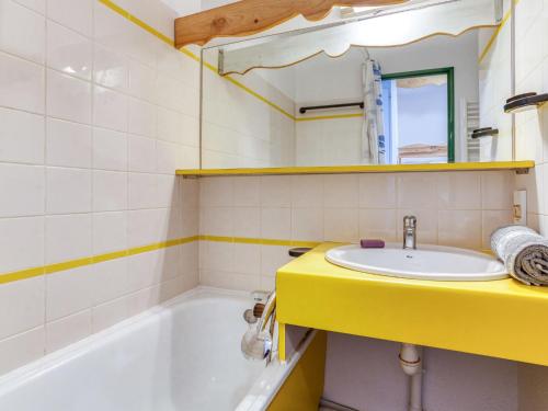 La salle de bains est pourvue d'un lavabo jaune et d'une baignoire. dans l'établissement Studio 503 Nécou by Interhome, aux Menuires