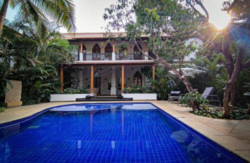 a large swimming pool in front of a house at The Postcard Saligao in Calangute