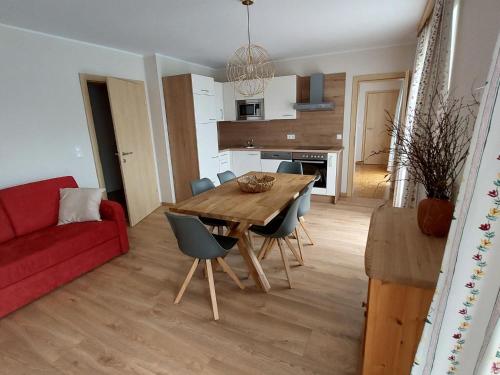 uma cozinha e sala de estar com uma mesa de madeira e cadeiras em Apartment Sonnenblume by Interhome em Velden am Wörthersee