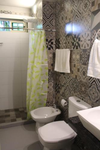 a bathroom with a toilet and a sink at Taguato Recoleta in Asunción
