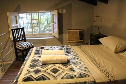 a bedroom with a large bed and a window at Taguato Recoleta in Asunción