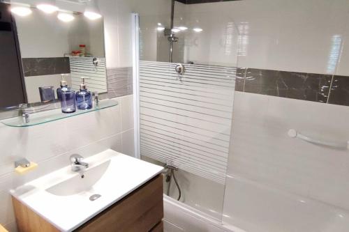 a white bathroom with a sink and a shower at MANHATTAN Studio Balcon Ensoleillé Parking Nord Montpellier in Grabels