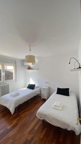 2 camas en una habitación con suelo de madera en Apartamento centro de Granada, en Granada