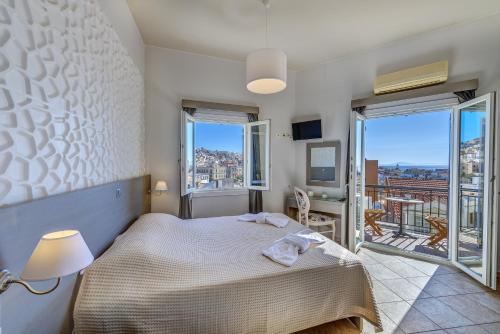 a bedroom with a bed and a balcony at Ethrion in Ermoupoli