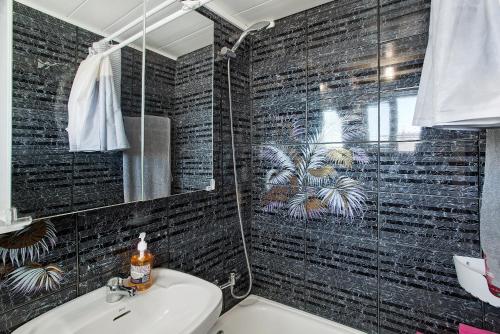 baño con una pared de azulejos negros en Casa Patricia en Vecindario