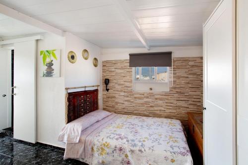een slaapkamer met een bed en een bakstenen muur bij Casa Patricia in Vecindario