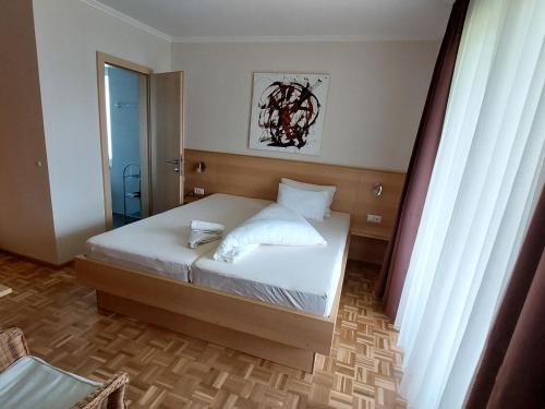 a bedroom with a bed with white sheets and pillows at Apartment Lilie by Interhome in Velden am Wörthersee