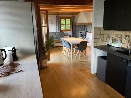a kitchen and living room with a table and chairs at Chalet Chalet 1627 by Interhome in Moleson